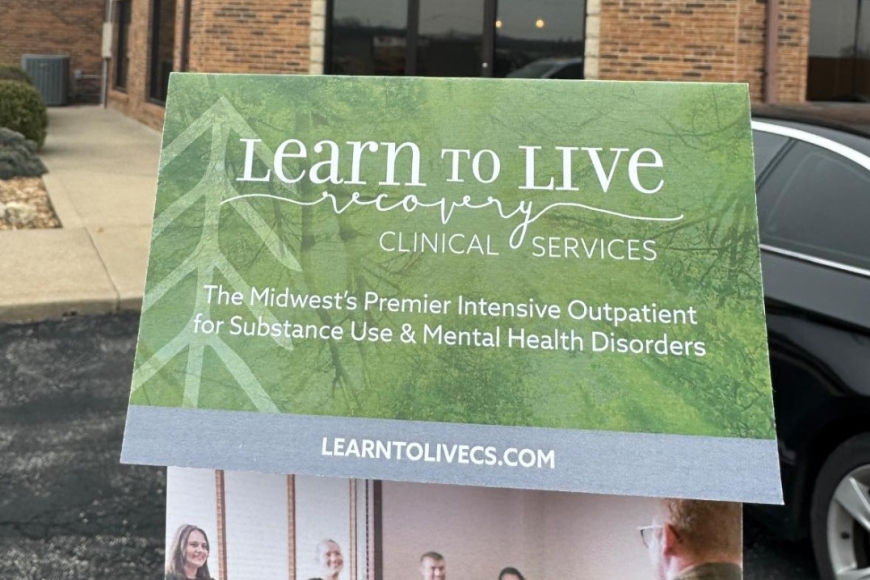 holding flyer by building